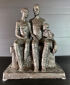 Hanne Varming: "Familie på bænk", figurgruppe af bronze. Sign. HV. H. 36. B. 26.