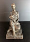 Hanne Varming: "Siddende mor med barn". Figur af brunpatineret bronze. Sign. HV 2/6. H. 28 cm.