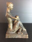 Hanne Varming: "Siddende mor med barn". Figur af brunpatineret bronze. Sign. HV 2/6. H. 28 cm.