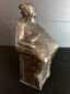Hanne Varming: "Kone på kassen". Figur af mørktpatineret bronze. Sign. HV 2/10. H. 22  cm.