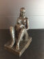 Hanne Varming: "Knælende mor med barn". Figur af brunpatineret bronze. Sign. HV . H. 25 cm.
