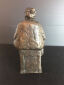 Hanne Varming: "Kone på kassen". Figur af mørktpatineret bronze. Sign. HV 2/10. H. 22  cm.